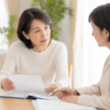 50代の女性がケアマネジャーと書類を見ながら介護保険の区分変更について相談している場面