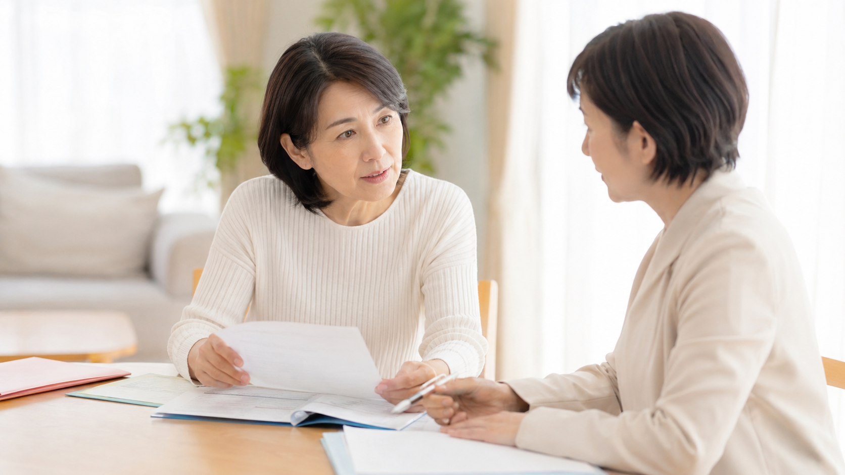 50代の女性がケアマネジャーと書類を見ながら介護保険の区分変更について相談している場面