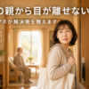 出かけようとして振り返る50代の娘と、奥のリビングに座る高齢の親